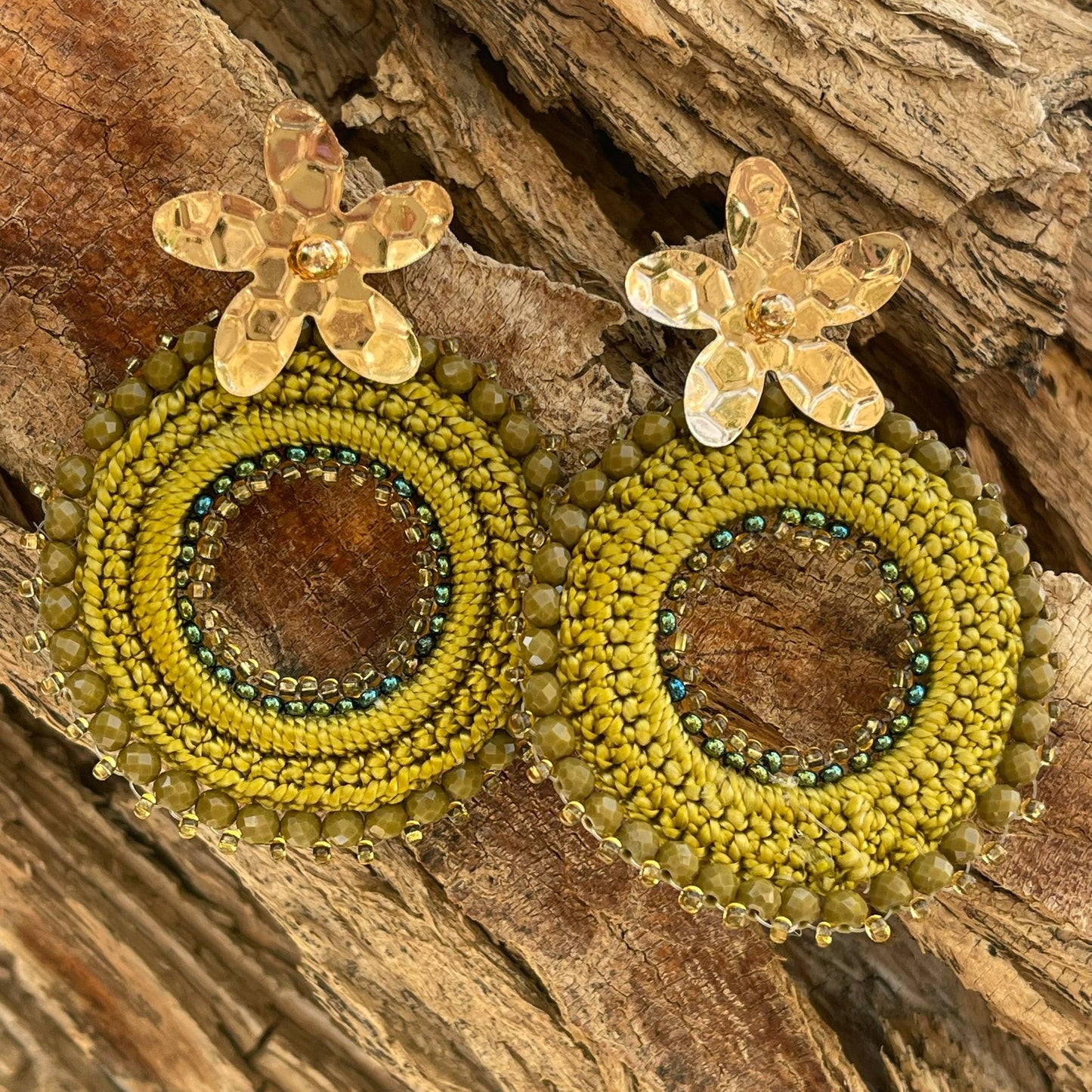 Woven round earrings with beads and golden flower-shaped clasp. Ref. NAT03