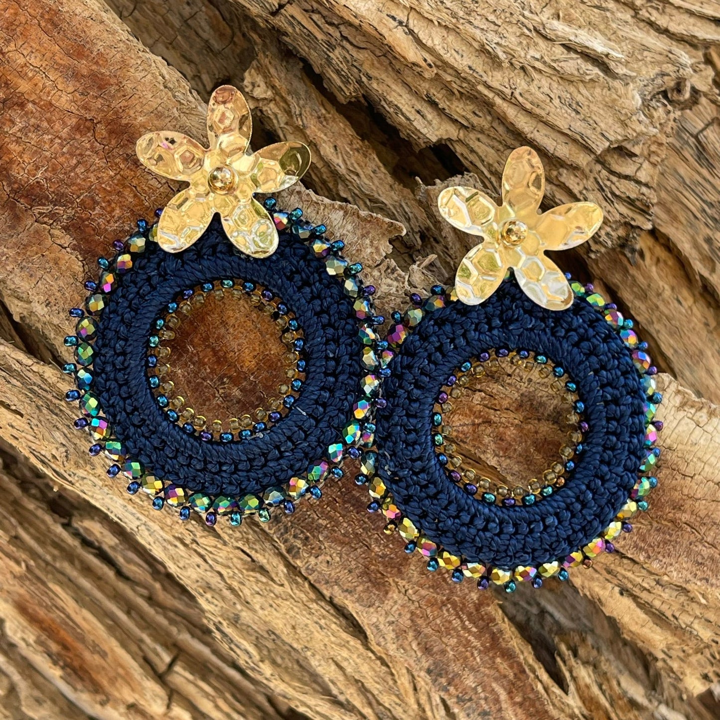 Woven round earrings with beads and golden flower-shaped clasp. Ref. NAT03