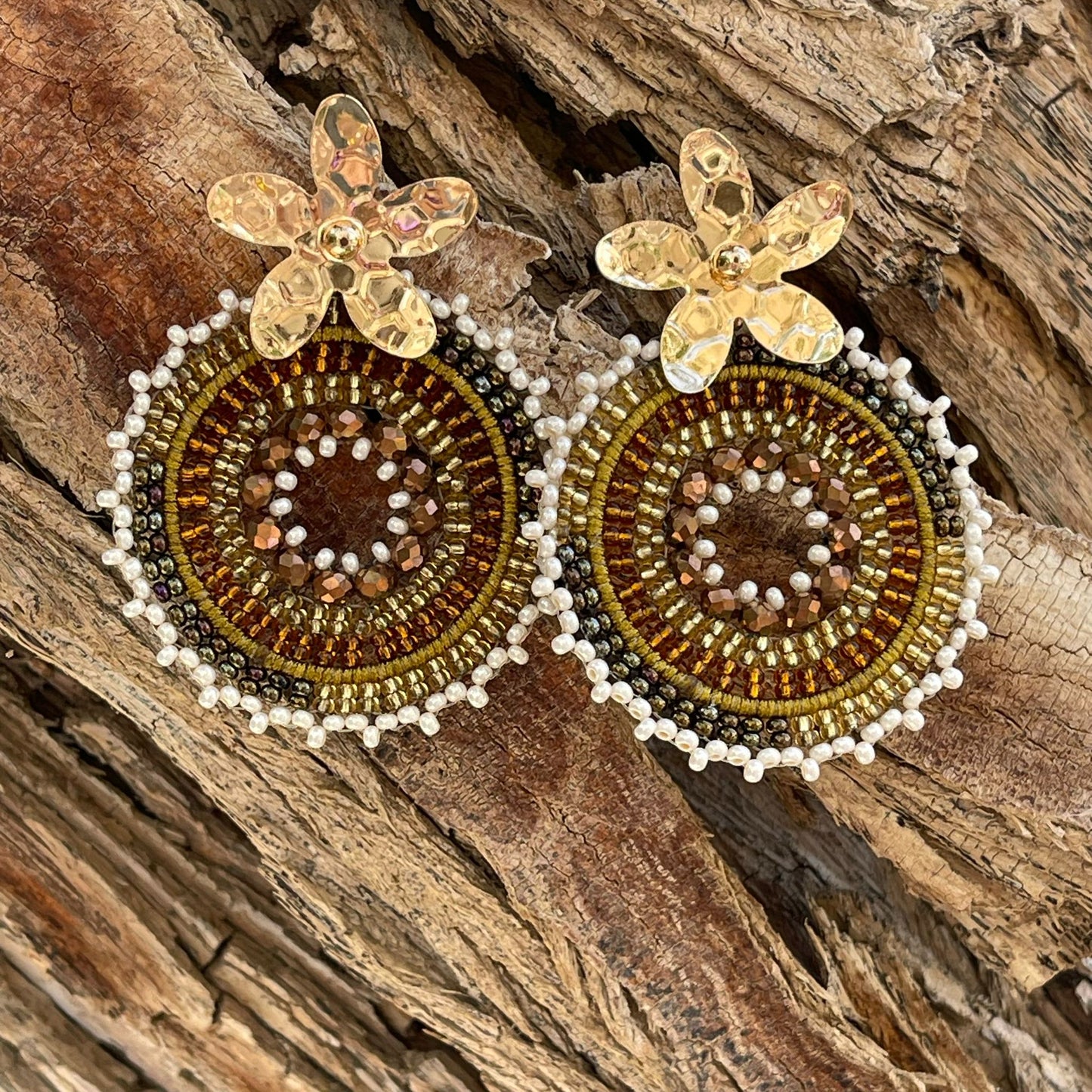 Woven round earrings with beads and golden flower-shaped clasp. Ref. NAT03