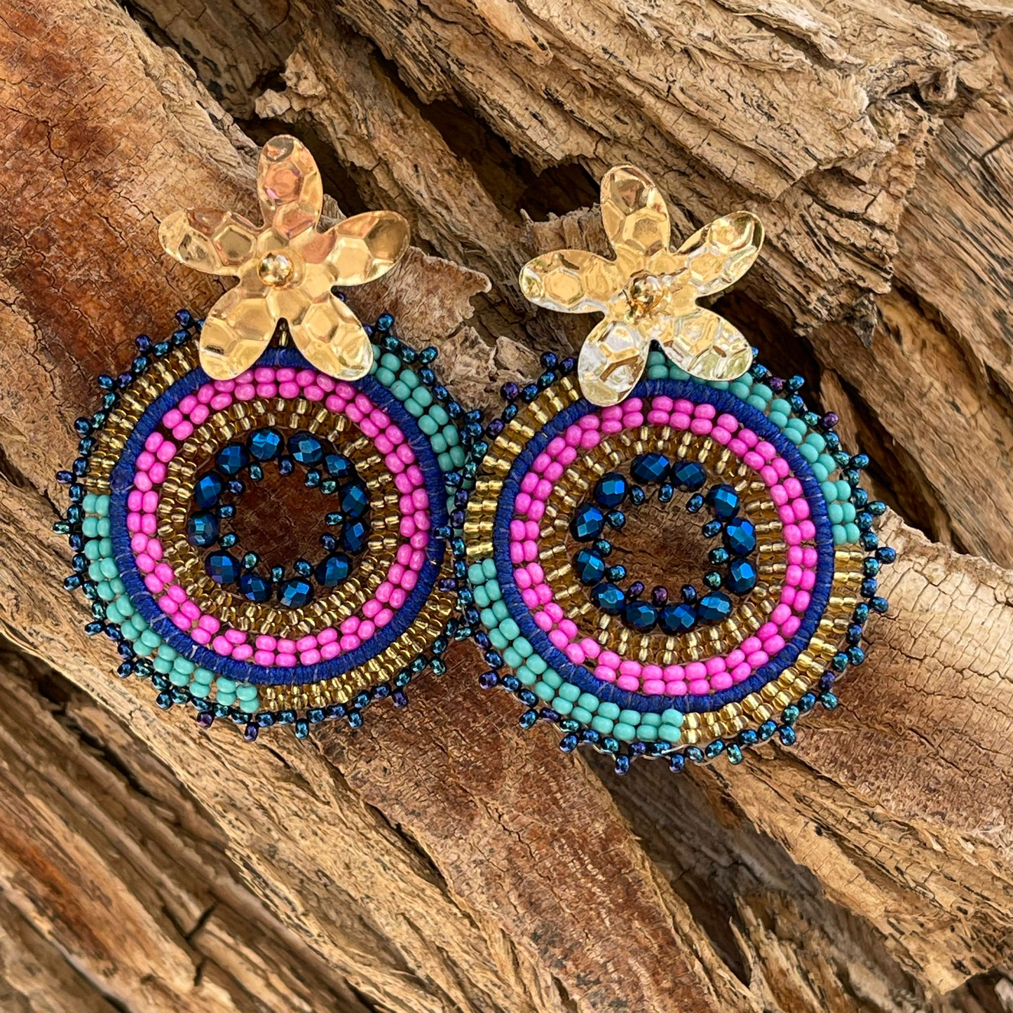 Woven round earrings with beads and golden flower-shaped clasp. Ref. NAT03