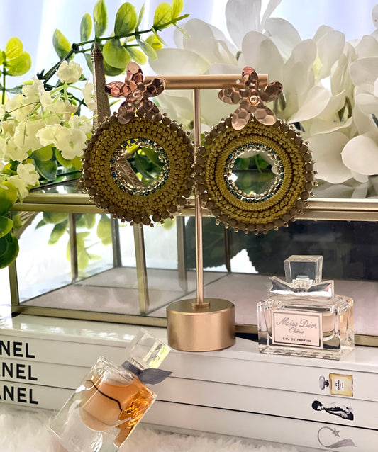 Woven round earrings with beads and golden flower-shaped clasp. Ref. NAT03